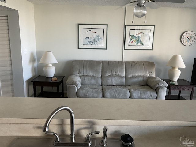 living room with ceiling fan and a textured ceiling