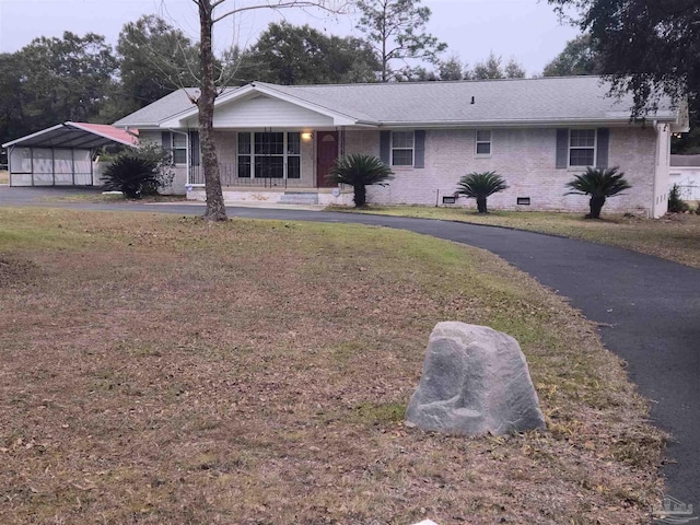 single story home featuring a carport, covered porch, and a front yard