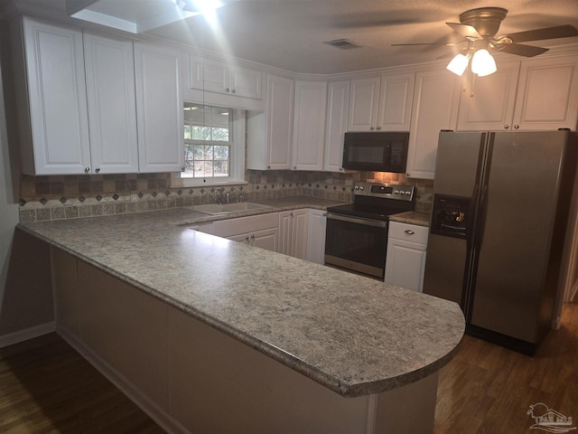 kitchen with kitchen peninsula, sink, white cabinetry, and stainless steel appliances