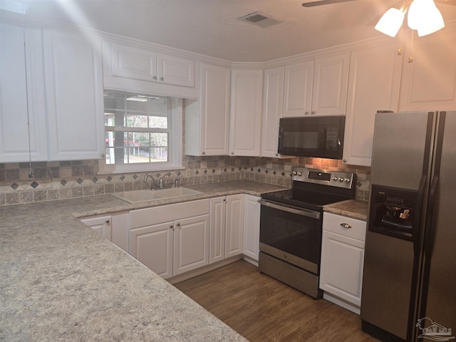 kitchen with appliances with stainless steel finishes, ceiling fan, sink, white cabinets, and dark hardwood / wood-style floors