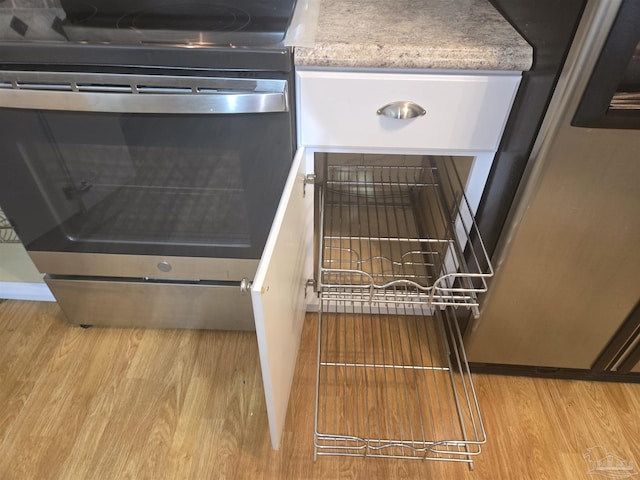 interior space with stainless steel range oven and light wood-type flooring