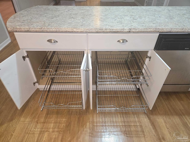 interior details featuring dishwasher and light hardwood / wood-style flooring