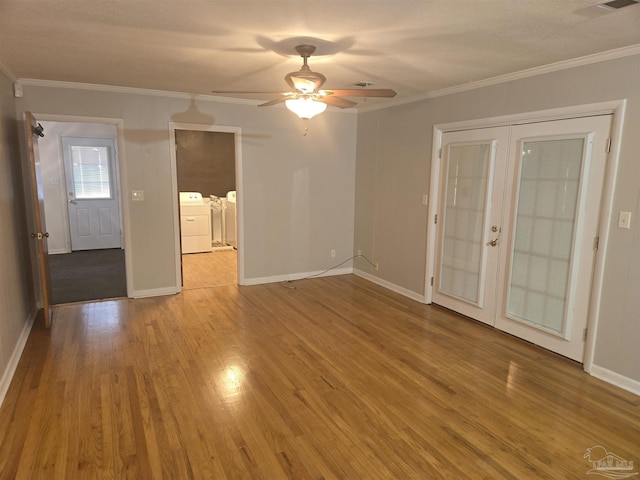 empty room with washer and dryer, french doors, ornamental molding, and hardwood / wood-style floors