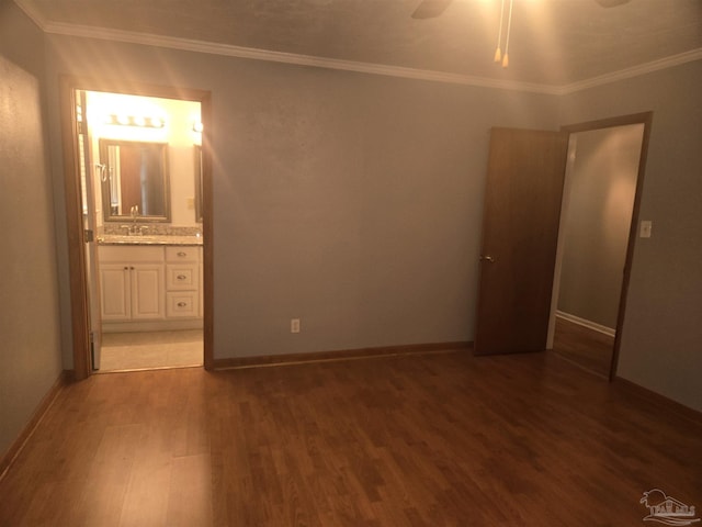 unfurnished bedroom featuring ornamental molding, ceiling fan, sink, connected bathroom, and dark hardwood / wood-style floors