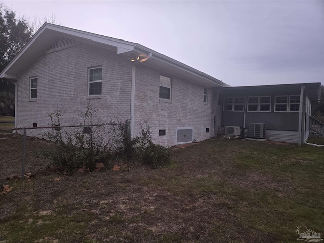 view of home's exterior with central AC and a lawn