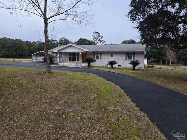 ranch-style house with covered porch, a front yard, and a carport