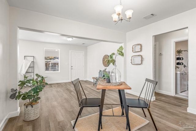 dining room with hardwood / wood-style flooring and an inviting chandelier