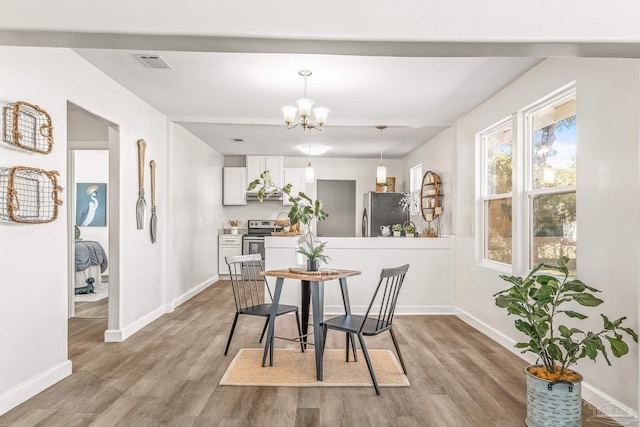 dining space with a notable chandelier and light wood-type flooring