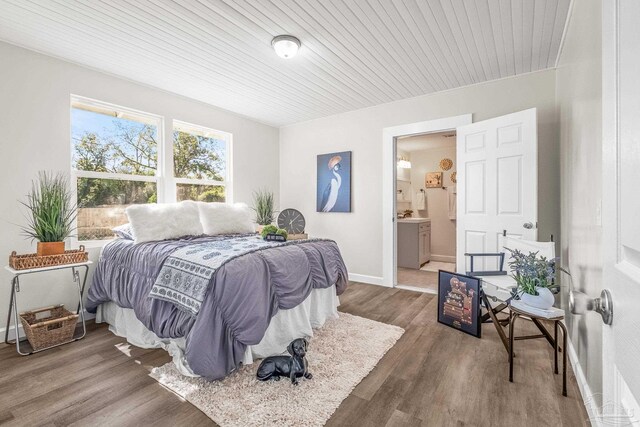 bedroom featuring ensuite bathroom, dark hardwood / wood-style floors, and wooden ceiling