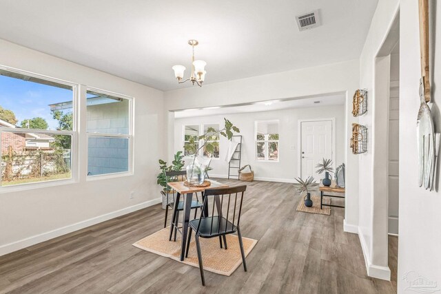 dining room featuring wood-type flooring and an inviting chandelier