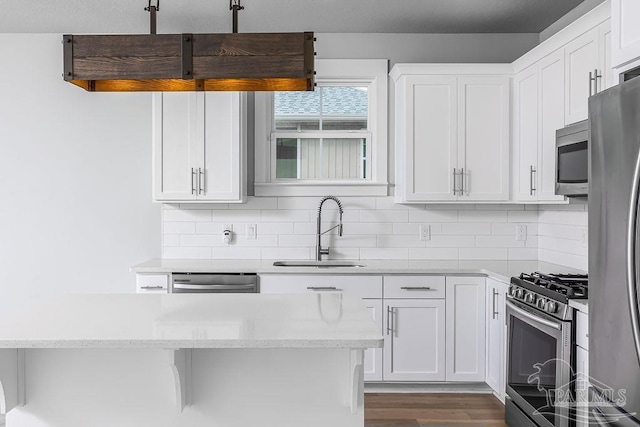 kitchen with stainless steel appliances, sink, tasteful backsplash, dark hardwood / wood-style floors, and white cabinetry