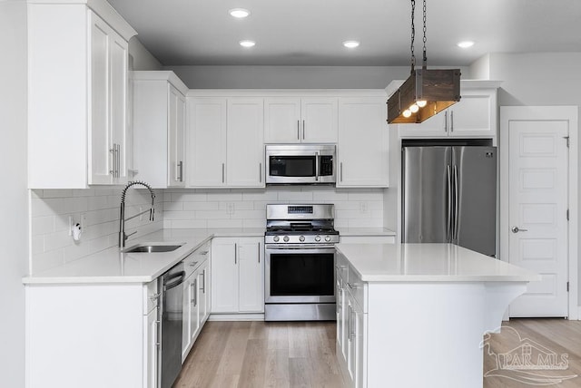 kitchen featuring white cabinets, stainless steel appliances, and hanging light fixtures