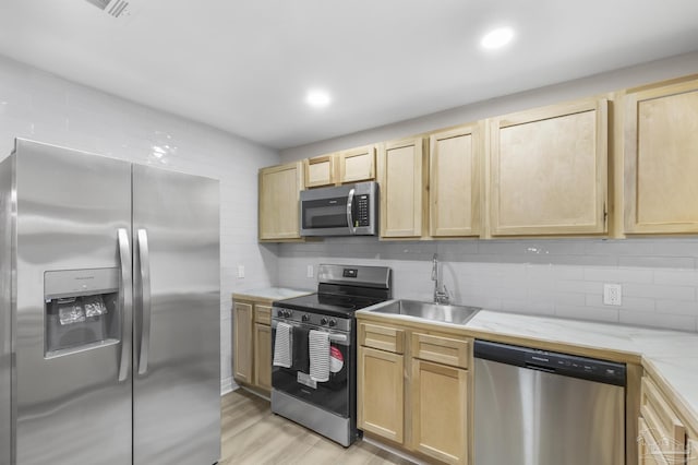 kitchen with sink, backsplash, stainless steel appliances, and light brown cabinets