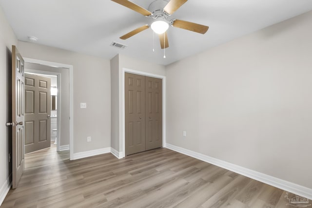 unfurnished bedroom featuring ceiling fan, a closet, and light hardwood / wood-style flooring