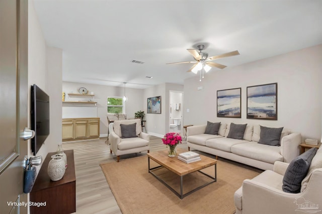 living room featuring ceiling fan and light wood-type flooring