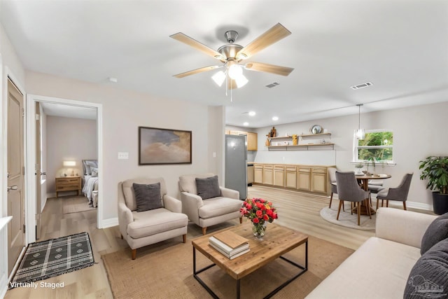 living room featuring ceiling fan and light wood-type flooring