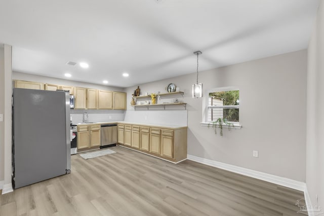 kitchen with sink, appliances with stainless steel finishes, light brown cabinetry, decorative light fixtures, and light wood-type flooring