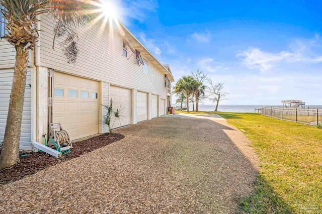 garage featuring fence and a water view