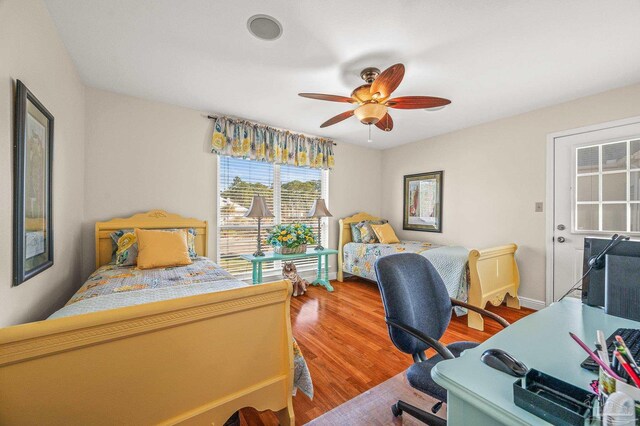 bedroom featuring baseboards, wood finished floors, and a ceiling fan