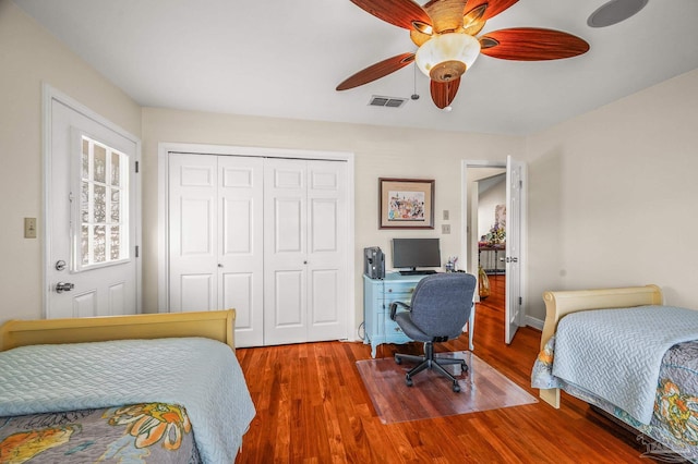 bedroom featuring a closet, visible vents, ceiling fan, and wood finished floors