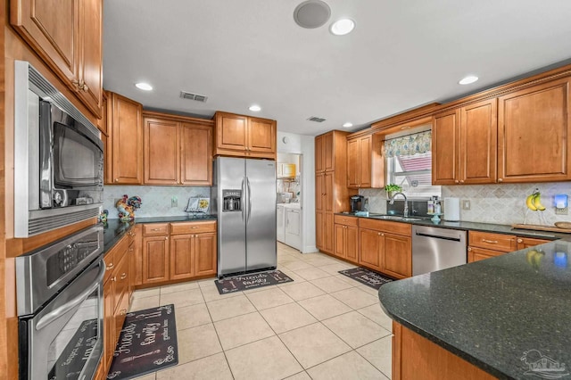 kitchen featuring brown cabinetry, visible vents, appliances with stainless steel finishes, and a sink