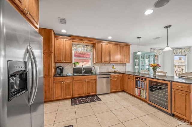 kitchen with dark countertops, visible vents, wine cooler, stainless steel appliances, and a sink