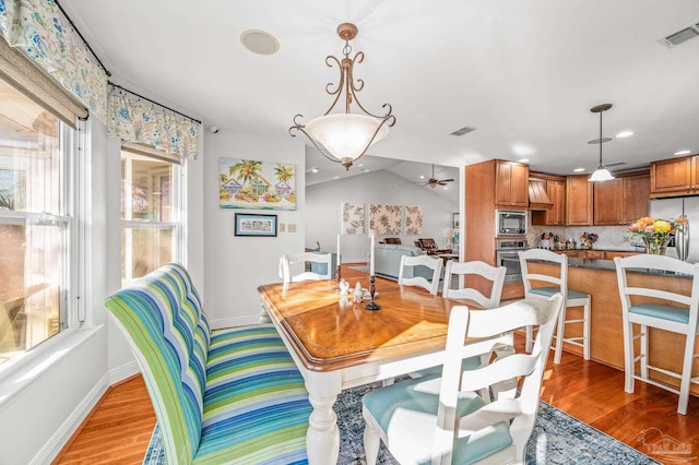 dining space with baseboards, visible vents, and light wood finished floors