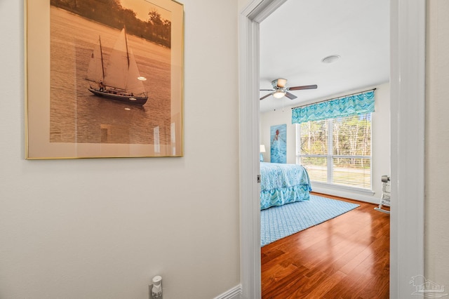 hall featuring baseboards and wood finished floors