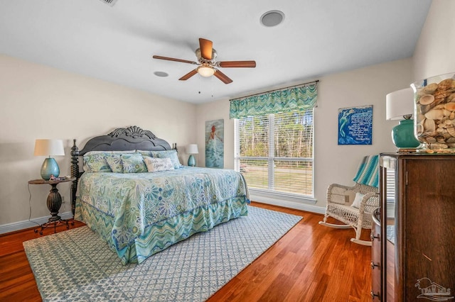 bedroom featuring ceiling fan, baseboards, and wood finished floors