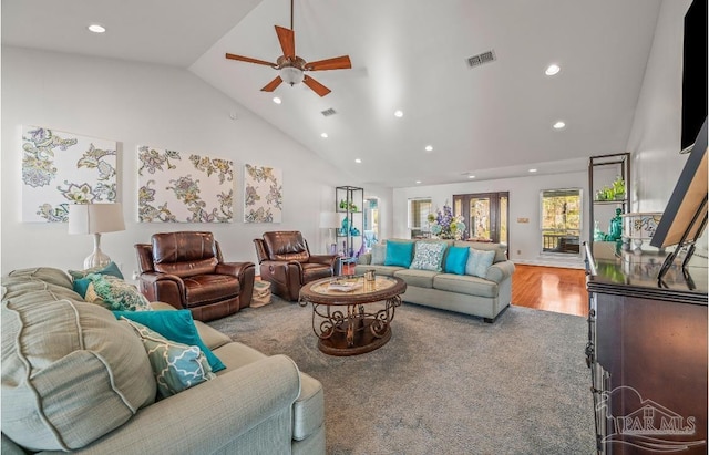 living area featuring visible vents, recessed lighting, high vaulted ceiling, and wood finished floors