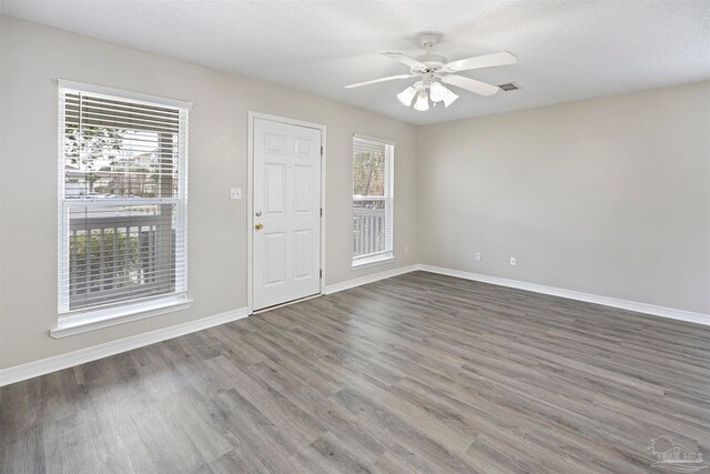 unfurnished room featuring dark hardwood / wood-style floors, ceiling fan, and a textured ceiling