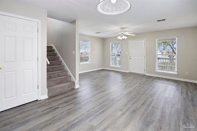 interior space with ceiling fan, wood-type flooring, and a textured ceiling