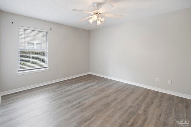 unfurnished room with hardwood / wood-style floors, ceiling fan, and a textured ceiling