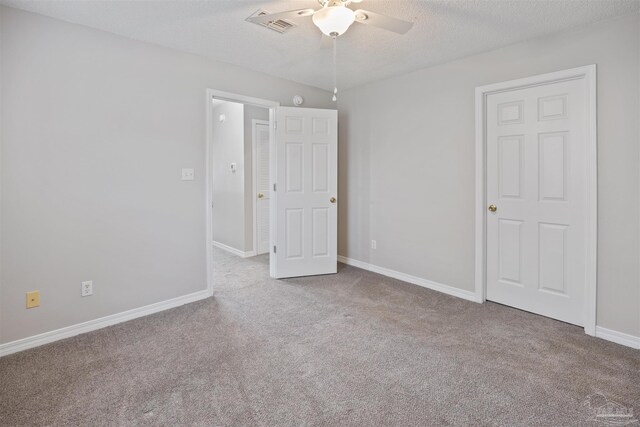 unfurnished bedroom featuring ceiling fan, light carpet, and a textured ceiling