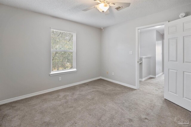 spare room with light carpet, a textured ceiling, and ceiling fan