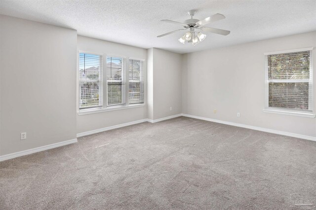 unfurnished room featuring a textured ceiling, carpet floors, and ceiling fan