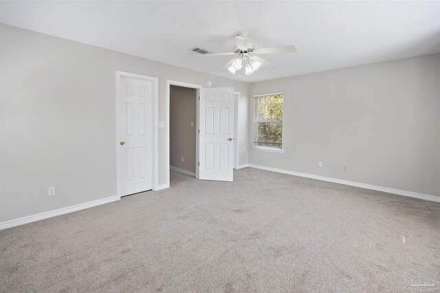 empty room with ceiling fan and light carpet