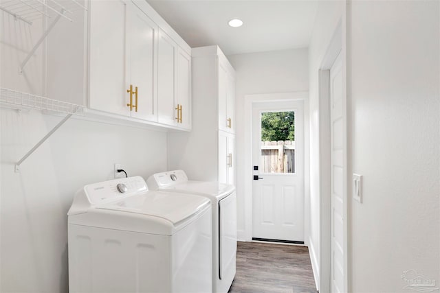 laundry area with hardwood / wood-style flooring, cabinets, and separate washer and dryer