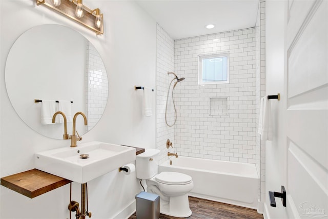 full bathroom featuring sink, toilet, hardwood / wood-style floors, and tiled shower / bath