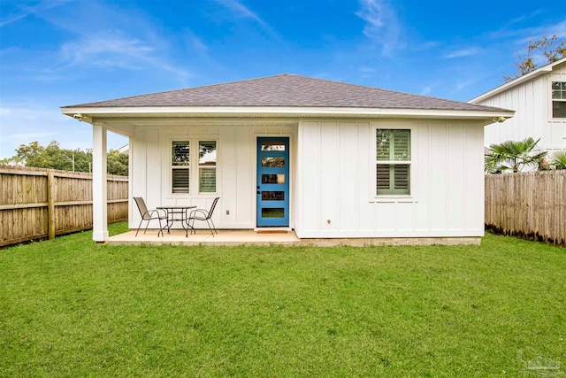 rear view of property featuring a patio area and a lawn