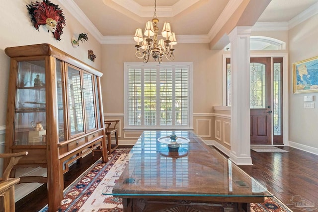 dining area with ornamental molding, a chandelier, ornate columns, and dark hardwood / wood-style floors