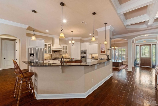 kitchen featuring a spacious island, stainless steel appliances, pendant lighting, and white cabinets