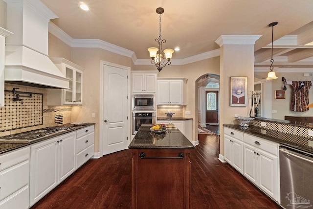 kitchen featuring dark hardwood / wood-style floors, custom range hood, a center island, decorative light fixtures, and white cabinets