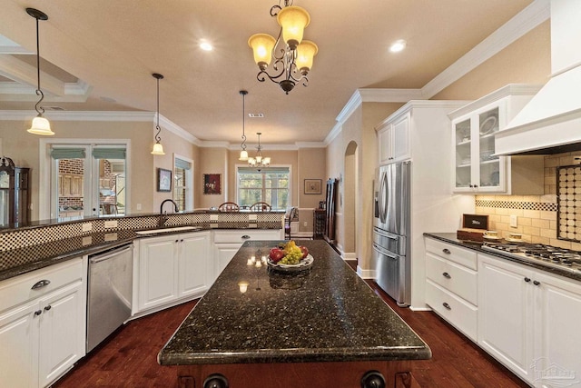 kitchen with appliances with stainless steel finishes, dark hardwood / wood-style flooring, sink, and a large island with sink