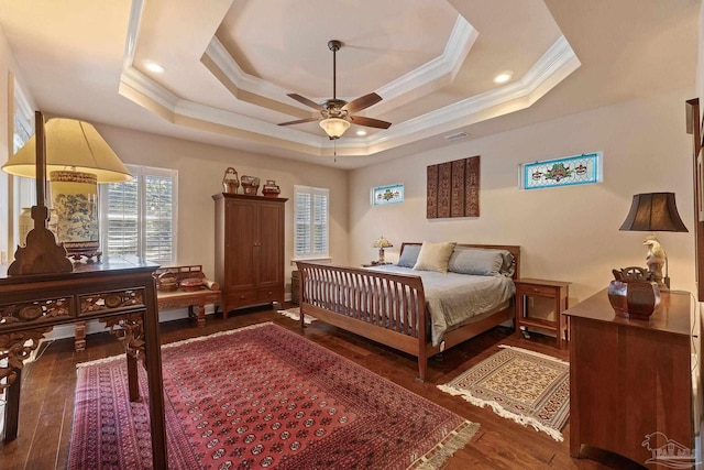 bedroom with ceiling fan, a raised ceiling, crown molding, and dark hardwood / wood-style floors