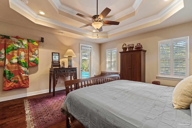 bedroom with ceiling fan, a raised ceiling, ornamental molding, and dark hardwood / wood-style floors