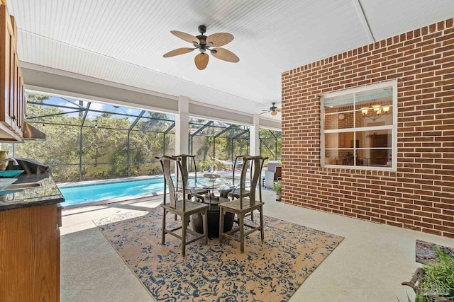 view of patio with ceiling fan and glass enclosure