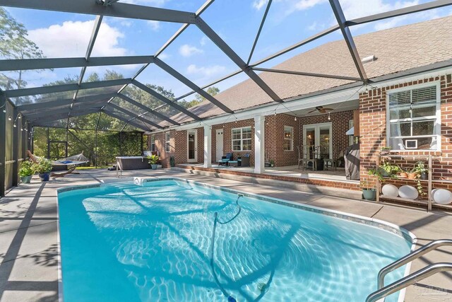 view of pool featuring french doors, ceiling fan, glass enclosure, and a patio area