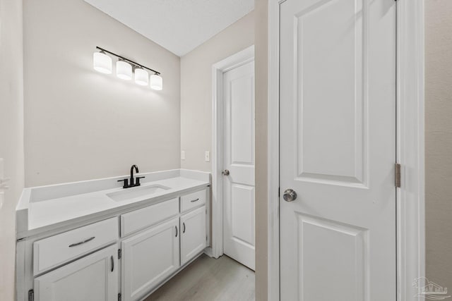 bathroom with vanity, a textured ceiling, and hardwood / wood-style flooring