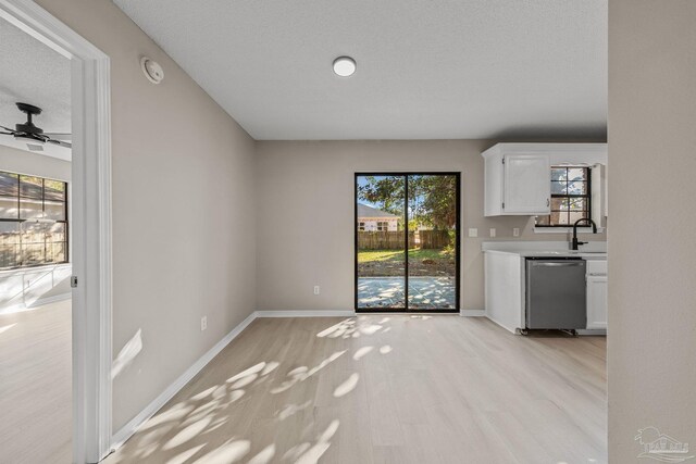 unfurnished living room with plenty of natural light, ceiling fan, and light wood-type flooring